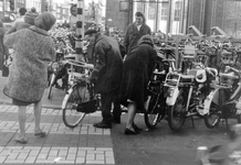 848393 Afbeelding van de rijwielstalling van A.M. Pouw, met gestalde fietsen en bromfietsen op de Oudegracht bij de ...